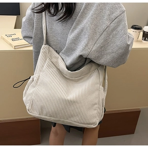 Detail view of the soft corduroy texture and spacious design of the beige tote bag