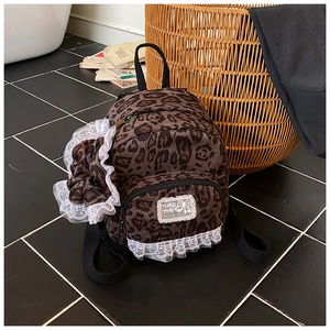 Detail of leopard print mini backpack with white lace trim and matching scrunchie set