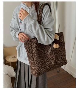 Close-up of leopard print canvas tote bag with a cute plush bear pendant accessory