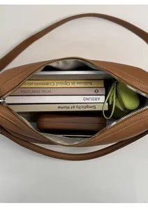 Interior view showing large capacity of the brown lychee leather shoulder bag with items