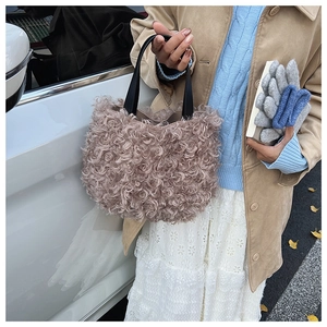 Close-up of curly faux fur texture on a dusty pink bucket bag with black handle