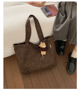 Close-up of leopard print canvas tote bag with a cute plush bear charm accessory