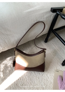 Detail der minimalistischen Halbmond-Achseltasche aus braunem Leder und khakifarbenem Wildleder