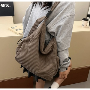 Detail of coffee brown corduroy crossbody bag with vertical ribbed texture and wide strap