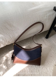 Detail der Retro-Beuteltasche aus blauem Nubuk und braunem Leder mit feiner Textur