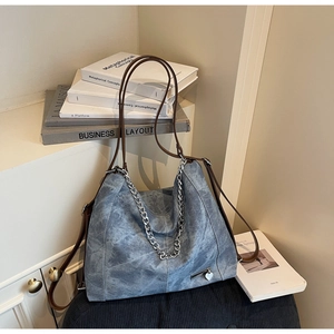 Detailed shot of vintage grey-blue tote with silver heart charm and leather straps