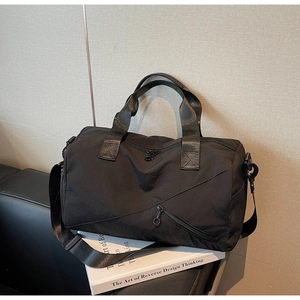 Détail du sac de voyage en nylon noir imperméable avec poches zippées sur canapé cuir