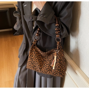 Detail der Tasche mit Leopardenmuster, Holzperlengriff und Perlenquasten-Anhänger