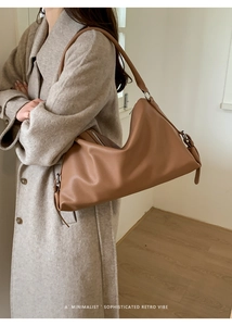 Detail of caramel leather hobo bag with silver hardware on a model's shoulder