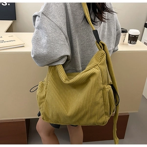 Detail of a ginger yellow corduroy hobo bag with adjustable strap and large capacity