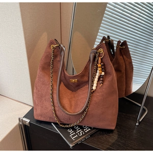 Detail of dark brown suede Hobo bag with gold chain strap and decorative beads