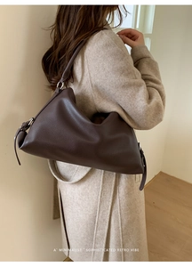Brown lychee leather shoulder bag detail on model with minimalist retro aesthetic