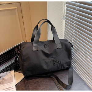 Détail du sac de voyage en nylon imperméable avec poche zippée diagonale et doubles poignées