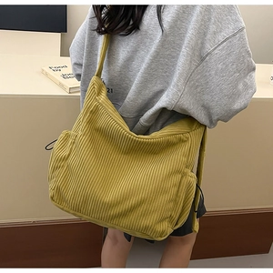 Detailed texture of yellow corduroy crossbody bag with adjustable drawstring side ties