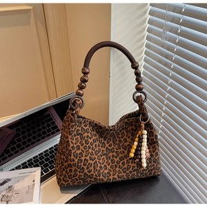 Detail der Leopardenmuster Tasche mit Vintage-Holzperlengriff und Perlenanhänger