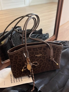 Sac fourre-tout tendance à motif léopard avec de longues anses et un pendentif raquette