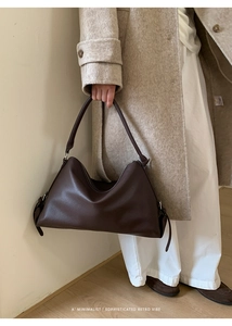 Detailed side view of deep brown pebbled leather handbag with adjustable metal buckles