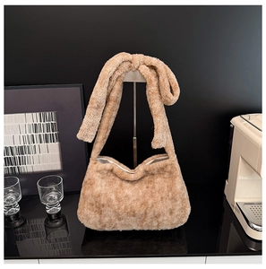 Detail of soft brown faux fur bucket bag featuring a unique wide knotted shoulder strap