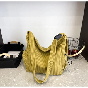 Detail view of the mustard yellow corduroy tote bag featuring adjustable shoulder strap