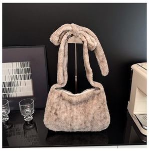 Close-up of camel plush tote bag featuring soft faux fur texture and knotted handle detail
