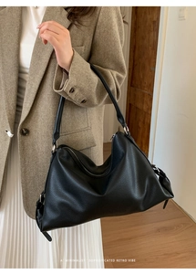 Close-up of black litchi grain leather shoulder bag with sleek silver hardware detail