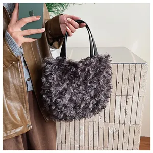 Dettaglio della borsa a secchiello in peluche grigio-viola con montone riccio e manici neri