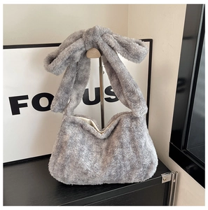 Détail d'un sac cabas gris en peluche avec texture douce et poignée nouée au design unique