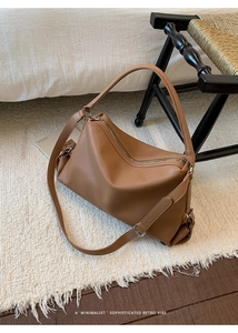 Close-up of brown litchi pattern leather shoulder bag with smooth metal zipper detail