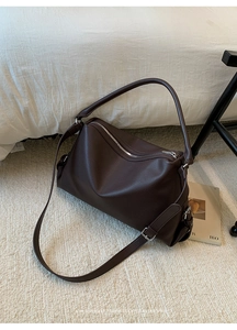 Detail of deep brown lychee grain leather tote with silver zipper and adjustable strap