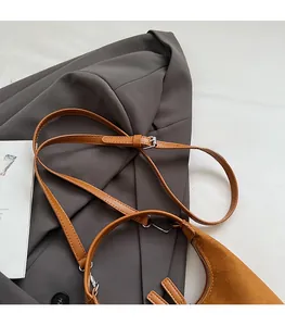 Gros plan détaillé d'une bandoulière en daim marron avec boucle réglable en métal argenté