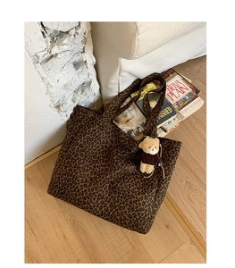 Detailed close-up of leopard print canvas tote bag with a cute plush bear pendant accessory