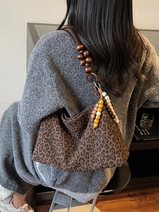 Schultertasche mit Leopardenmuster, großem Holzperlen-Riemen und farbenfrohem Quasten-Detail