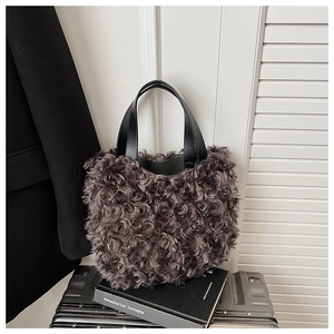 Detailed view of dark purple faux fur bucket bag with black leather handles for winter