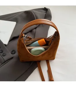 Vue de dessus du sac croissant en daim marron montrant l'espace intérieur et les cosmétiques