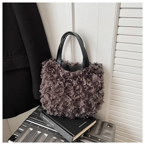 Dettaglio della borsa a secchiello in peluche grigio scuro con texture a rose