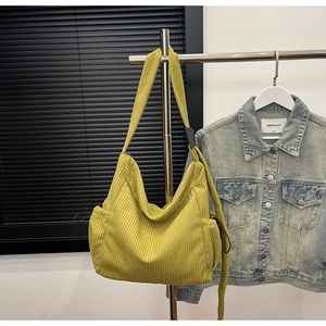 Detailed view of avocado green corduroy tote bag featuring side drawstring pocket and texture