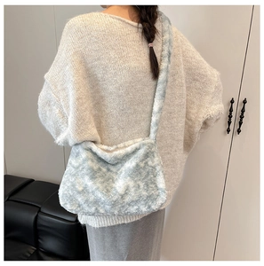 Gros plan sur la texture du sac bandoulière en peluche bleu clair et fausse fourrure