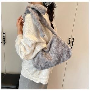 Detail of soft grey faux fur bucket bag with plush wide strap for autumn winter style