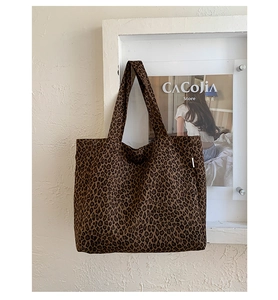 Detailed close-up of leopard print canvas tote bag featuring thick fabric and wide shoulder strap