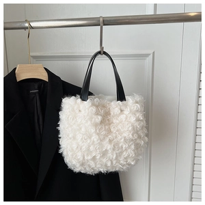 Dettaglio borsa a secchiello in peluche bianco con trama a rose e manici in pelle nera