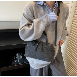 Detail showing the quilted texture and golden zipper hardware of the black crossbody bag