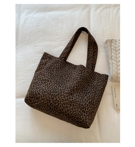 Close-up detail of leopard print canvas tote bag with thick fabric texture and wide straps