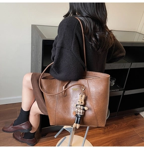 Brown large capacity tote bag with long shoulder straps and a cute rabbit pendant accessory