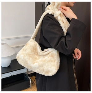 Chic sac à bandoulière en fausse fourrure crème porté avec un blazer noir ajusté