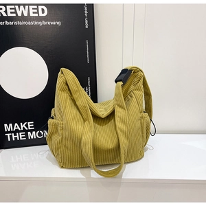Detail of mustard yellow corduroy tote bag featuring adjustable strap and side drawstring