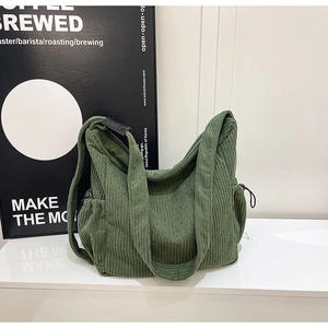 Close-up of dark green corduroy hobo bag texture with drawstring pocket side detail