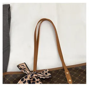 Détail d'un sac cabas marron avec motif géométrique vintage et foulard léopard au manche