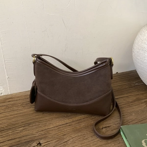 Close-up of vintage brown suede patchwork bucket bag with gold hardware and NO FILTER logo