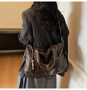 Vue latérale macro d'un grand sac cabas marron foncé avec un gland à perles élégant