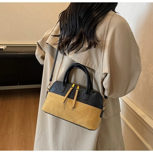 Model wearing a vintage quilted shell bag with contrast colors and long strap